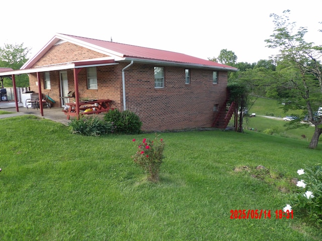 157 Deskins Ln, Frenchburg, KY 40322 - view of side of property featuring brick siding, a yard, and metal roof