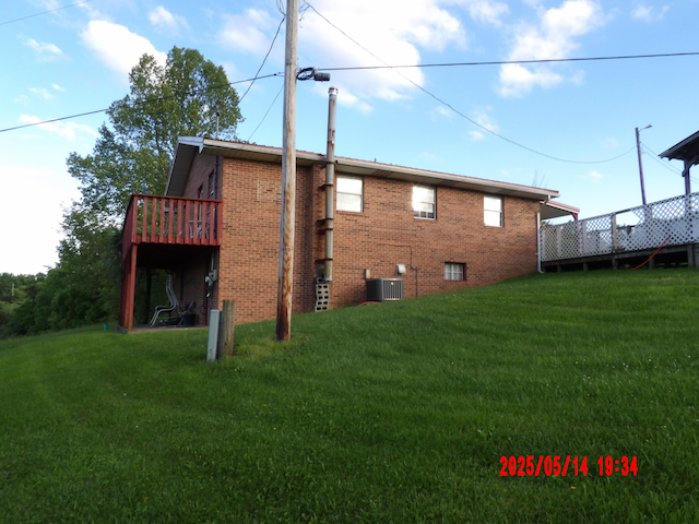 157 Deskins Ln, Frenchburg, KY 40322 - rear view of house featuring a yard, brick siding, a deck, and cooling unit