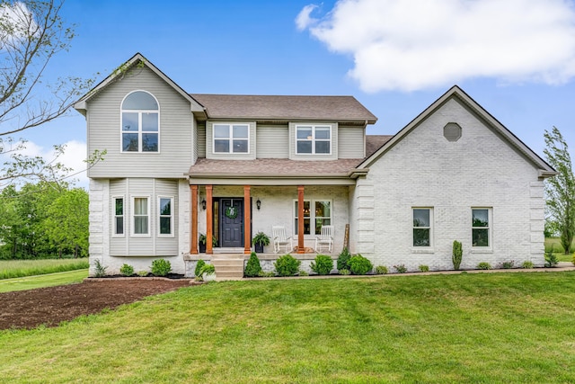 9118 Harrodsburg Rd, Wilmore, KY 40390 - view of front facade with covered porch, a front yard, brick siding, and roof with shingles