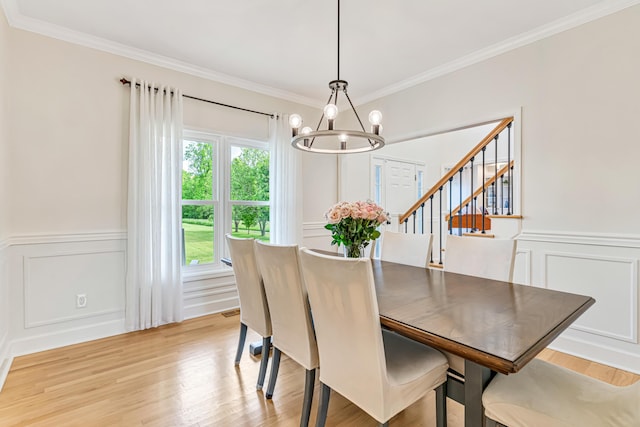 9118 Harrodsburg Rd, Wilmore, KY 40390 - dining room featuring a chandelier, a decorative wall, ornamental molding, light wood-style flooring, and a wainscoted wall