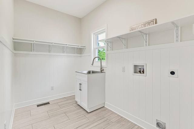 9118 Harrodsburg Rd, Wilmore, KY 40390 - laundry area with hookup for an electric dryer, washer hookup, baseboards, light wood finished floors, and cabinet space