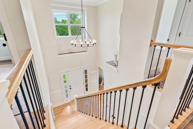 9118 Harrodsburg Rd, Wilmore, KY 40390 - staircase featuring a chandelier, wood finished floors, a towering ceiling, and ornamental molding