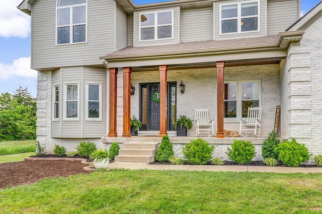9118 Harrodsburg Rd, Wilmore, KY 40390 - view of exterior entry featuring a porch, a yard, and brick siding