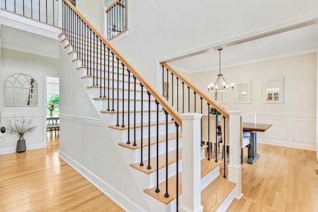9118 Harrodsburg Rd, Wilmore, KY 40390 - stairway with wood finished floors, a chandelier, crown molding, baseboards, and a high ceiling