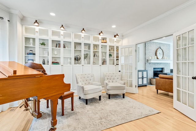 9118 Harrodsburg Rd, Wilmore, KY 40390 - living area with ornamental molding, wood finished floors, french doors, recessed lighting, and a stone fireplace