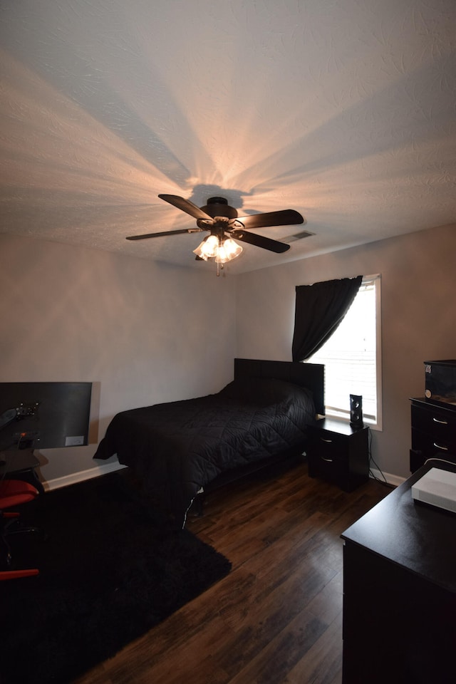 bedroom with dark wood-type flooring, an office area, and ceiling fan