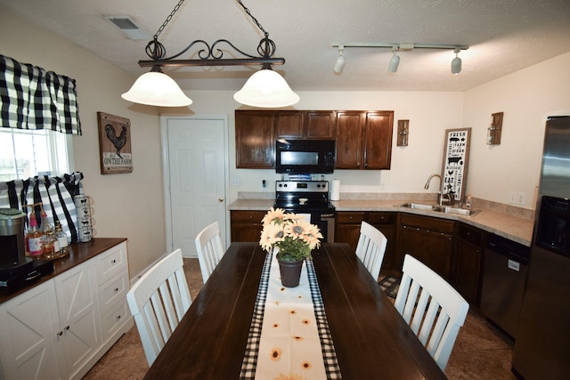 kitchen with stainless steel appliances, a sink, dark brown cabinets, decorative light fixtures, and light countertops