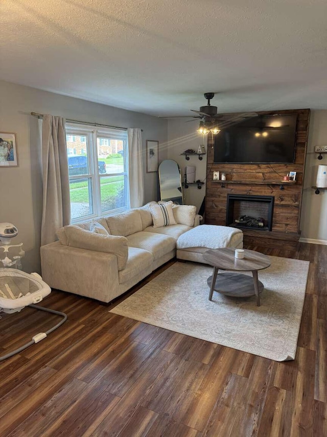 780 Nancy St, Versailles, KY 40383 - living area featuring dark wood-type flooring, a large fireplace, a ceiling fan, and a textured ceiling