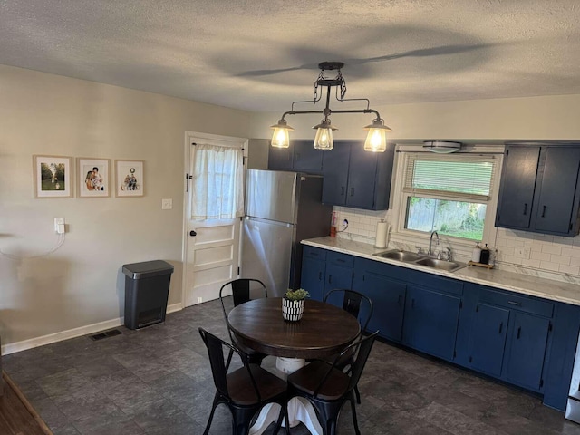 780 Nancy St, Versailles, KY 40383 - kitchen with blue cabinetry, a sink, freestanding refrigerator, healthy amount of natural light, and a textured ceiling