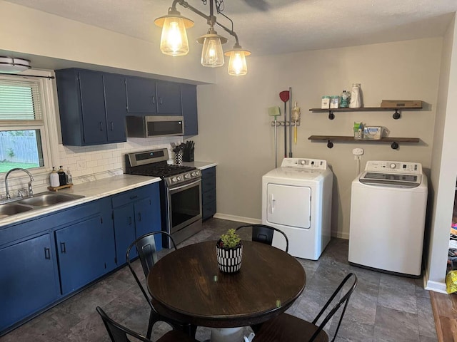 780 Nancy St, Versailles, KY 40383 - kitchen with stainless steel appliances, blue cabinets, washer and dryer, a sink, and tasteful backsplash