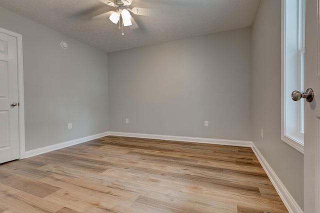unfurnished room with ceiling fan, light wood-style flooring, and baseboards