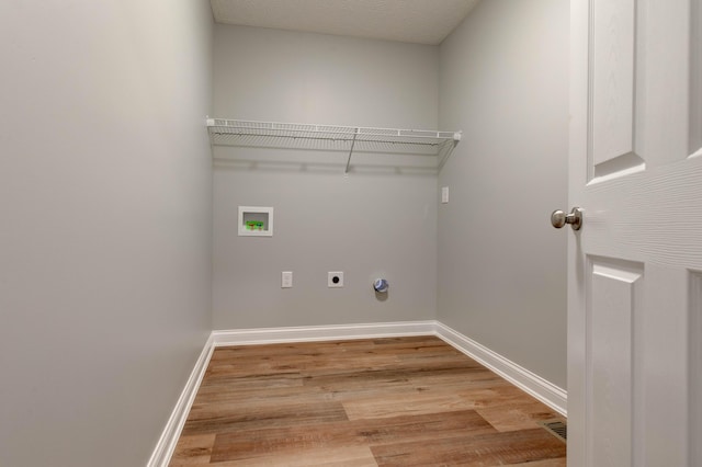 laundry room with electric dryer hookup, washer hookup, light wood-style flooring, and baseboards