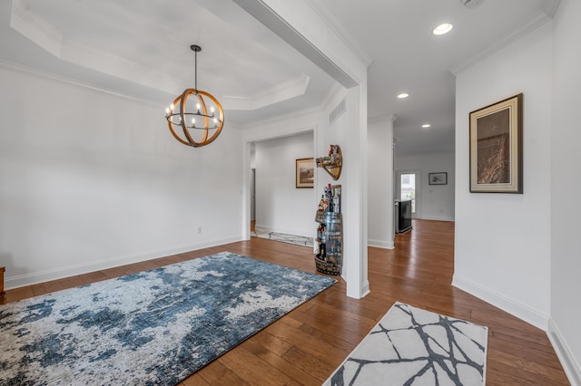 entryway with crown molding, a chandelier, wood-type flooring, baseboards, and recessed lighting