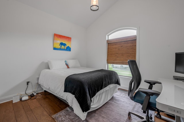 bedroom featuring an office area, wood finished floors, high vaulted ceiling, and baseboards