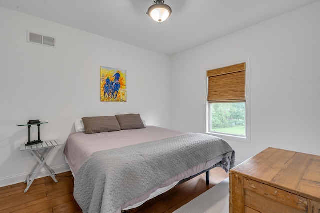 bedroom with hardwood / wood-style flooring and baseboards