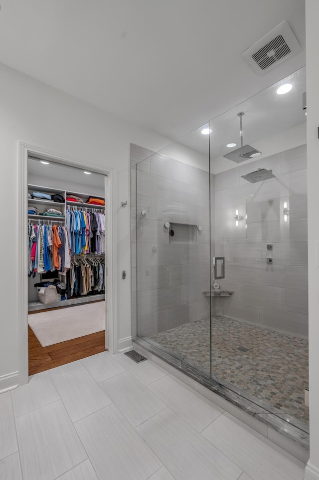 full bathroom featuring a stall shower, a spacious closet, recessed lighting, and baseboards