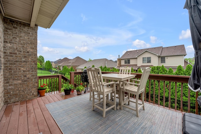 wooden deck featuring outdoor dining space and a residential view