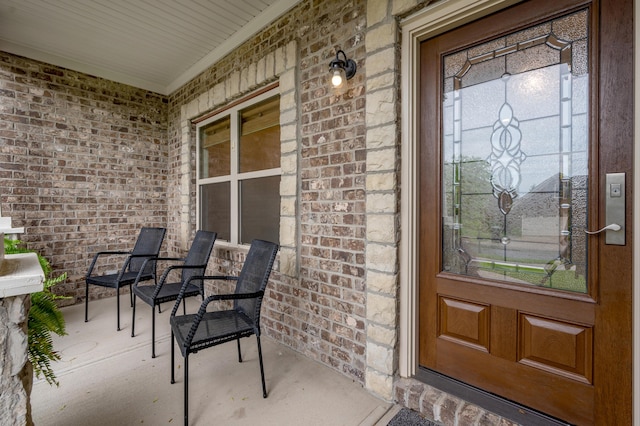 entrance to property featuring brick siding and a porch