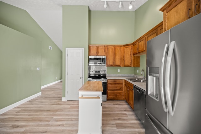 120 Chestnut Ln, Versailles, KY 40383 - kitchen featuring appliances with stainless steel finishes, a sink, high vaulted ceiling, a kitchen island, and rail lighting
