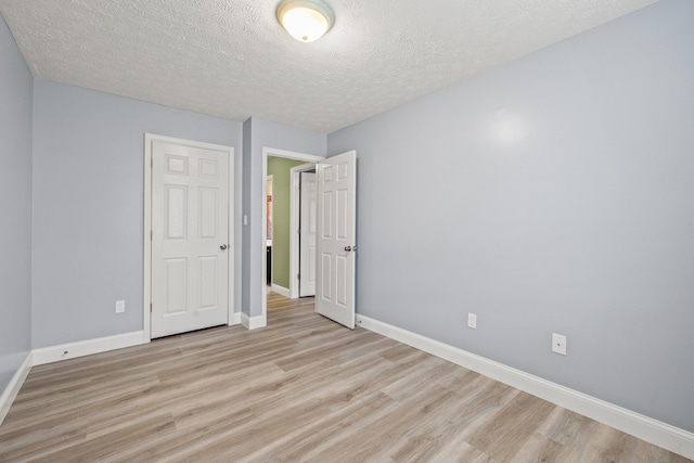 120 Chestnut Ln, Versailles, KY 40383 - unfurnished bedroom with light wood-type flooring, a textured ceiling, and baseboards