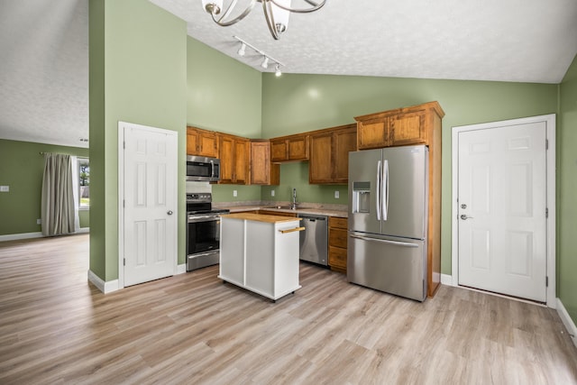 120 Chestnut Ln, Versailles, KY 40383 - kitchen featuring appliances with stainless steel finishes, high vaulted ceiling, light countertops, a center island, and a chandelier