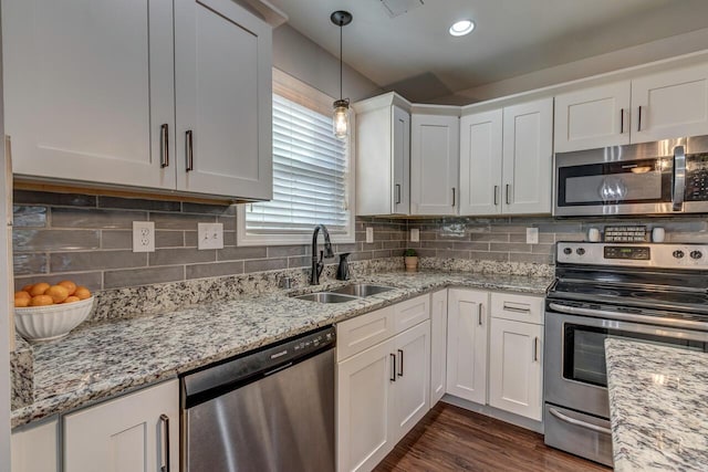 kitchen featuring appliances with stainless steel finishes, a sink, white cabinetry, and backsplash