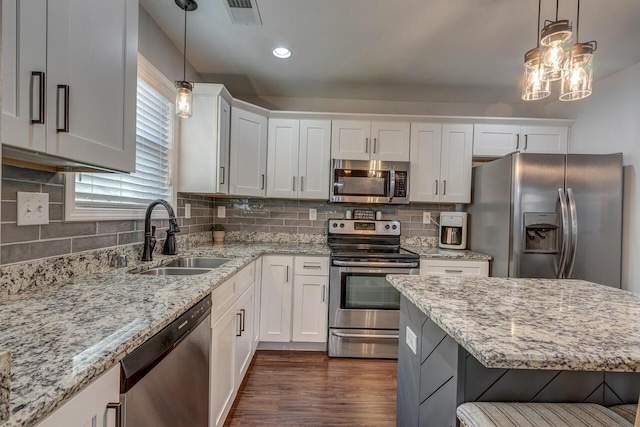 kitchen featuring stainless steel appliances, a sink, white cabinets, pendant lighting, and recessed lighting