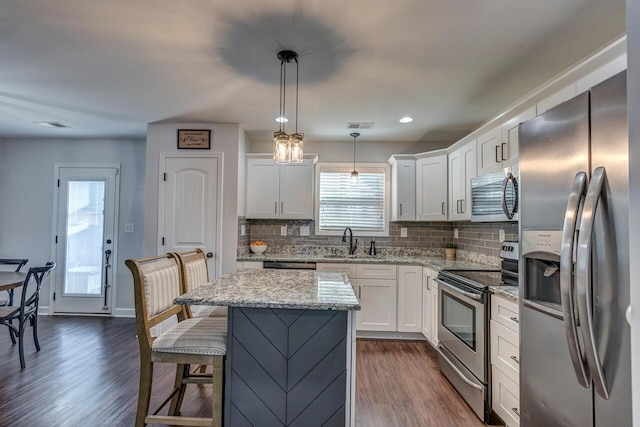 kitchen featuring appliances with stainless steel finishes, a sink, backsplash, white cabinets, and recessed lighting