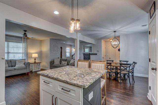 kitchen featuring ornate columns, baseboards, open floor plan, dark wood-type flooring, and recessed lighting