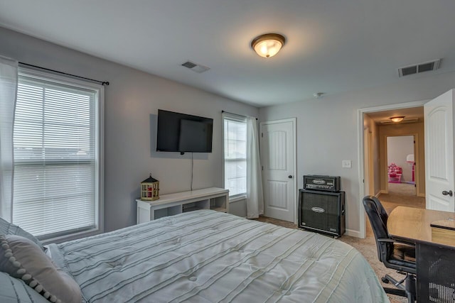 bedroom with light colored carpet, baseboards, a desk, and a closet
