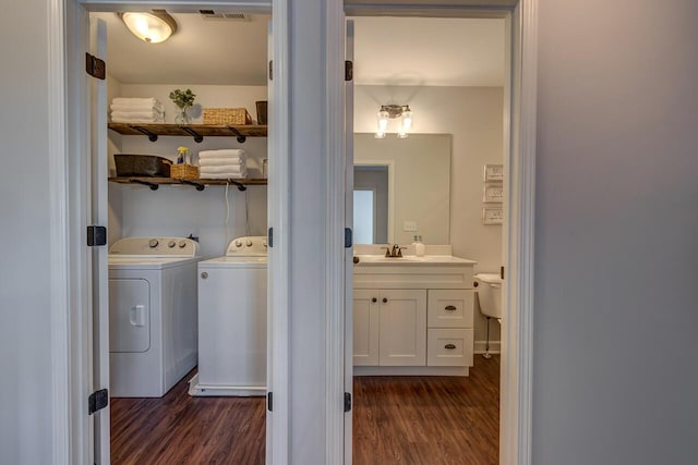 washroom with washer and dryer and dark wood-style flooring