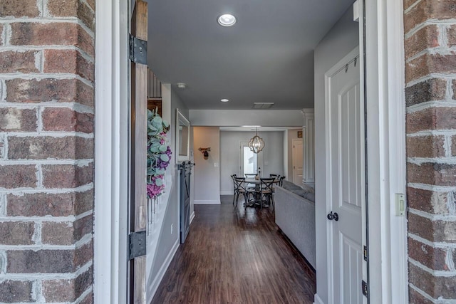 hallway with dark wood-type flooring, baseboards, and recessed lighting