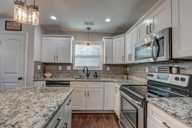 kitchen with appliances with stainless steel finishes, a sink, white cabinetry, dark wood finished floors, and recessed lighting