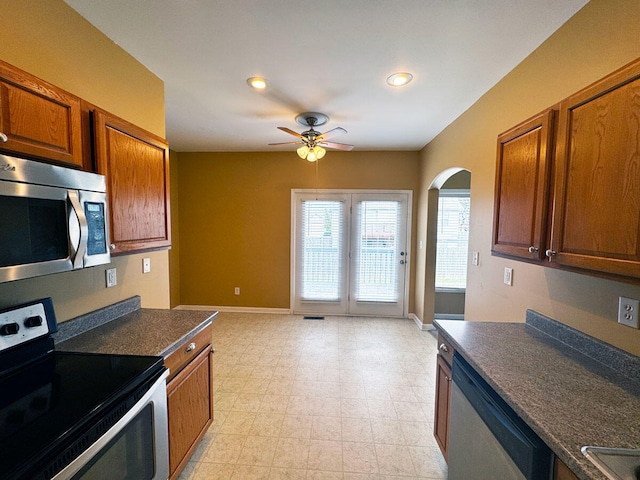 136 Janice Dr, Nicholasville, KY 40356 - kitchen featuring stainless steel appliances, a ceiling fan, dark countertops, arched walkways, and baseboards