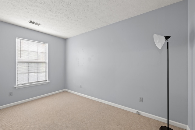 carpeted empty room featuring baseboards and a textured ceiling