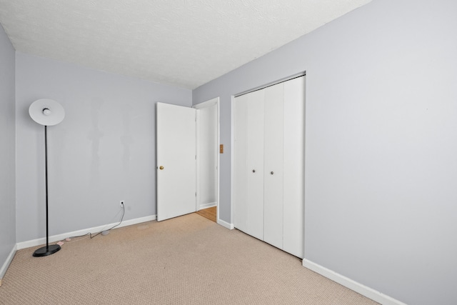 unfurnished bedroom with carpet flooring, baseboards, and a closet