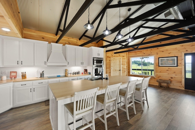 61 Cumberland Cv, Nancy, KY 42544 - kitchen with custom exhaust hood, wood walls, stainless steel appliances, beamed ceiling, and white cabinets
