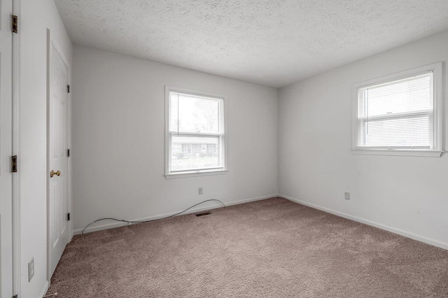 unfurnished bedroom featuring carpet flooring, a textured ceiling, and baseboards