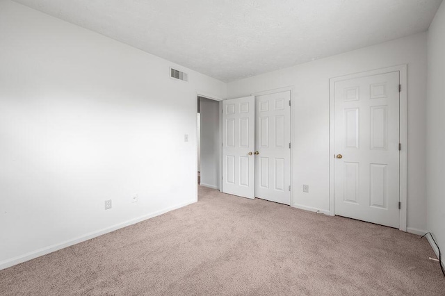 unfurnished bedroom featuring carpet floors, baseboards, and a closet