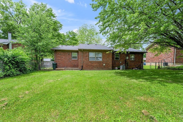 rear view of property featuring brick siding and central AC