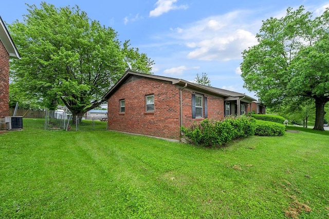 view of side of home with central air condition unit and brick siding