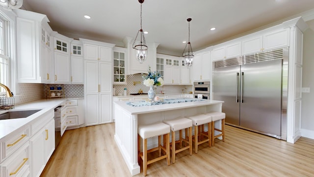 840 A T Dean Rd, Harrodsburg, KY 40330 - kitchen featuring appliances with stainless steel finishes, a sink, decorative backsplash, a center island, and light wood-style floors