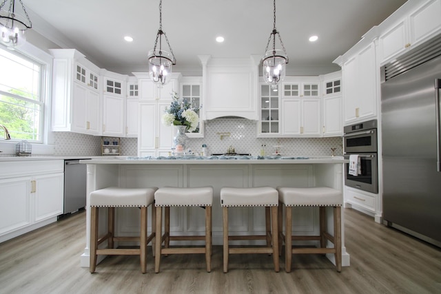 840 A T Dean Rd, Harrodsburg, KY 40330 - kitchen featuring appliances with stainless steel finishes, a chandelier, light wood finished floors, tasteful backsplash, and light countertops
