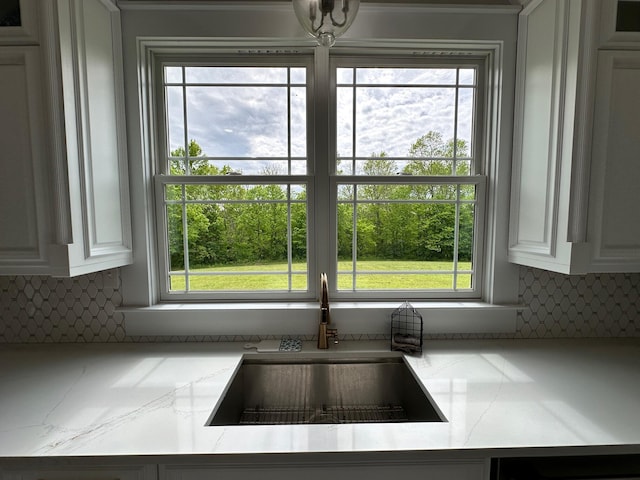 840 A T Dean Rd, Harrodsburg, KY 40330 - kitchen view of a sink, decorative backsplash, white cabinets, and light stone counters