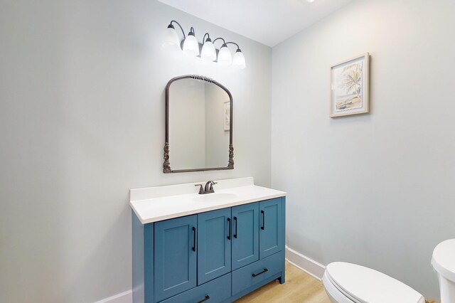 840 A T Dean Rd, Harrodsburg, KY 40330 - half bathroom featuring toilet, vanity, baseboards, and wood finished floors