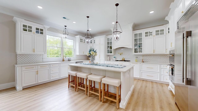 840 A T Dean Rd, Harrodsburg, KY 40330 - kitchen with gas stovetop, a kitchen island, light wood-type flooring, a kitchen bar, and light countertops