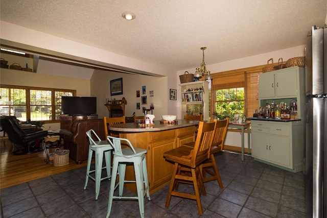 388 Mc Roberts Rd, Wallingford, KY 41093 - kitchen featuring a textured ceiling, plenty of natural light, freestanding refrigerator, a kitchen bar, and a center island