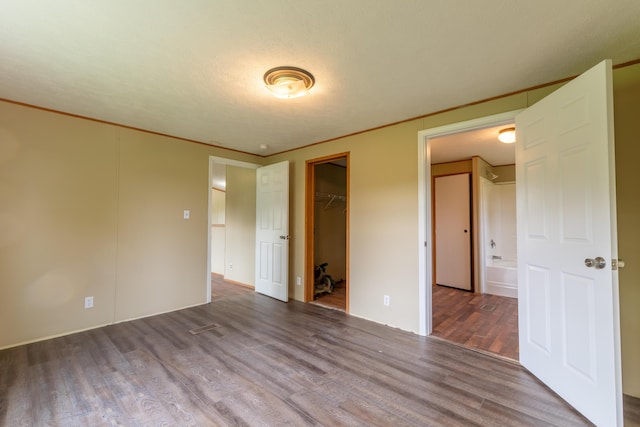 662 Clifty Hill Rd, Science Hill, KY 42553 - unfurnished bedroom featuring wood finished floors, a closet, a walk in closet, and crown molding