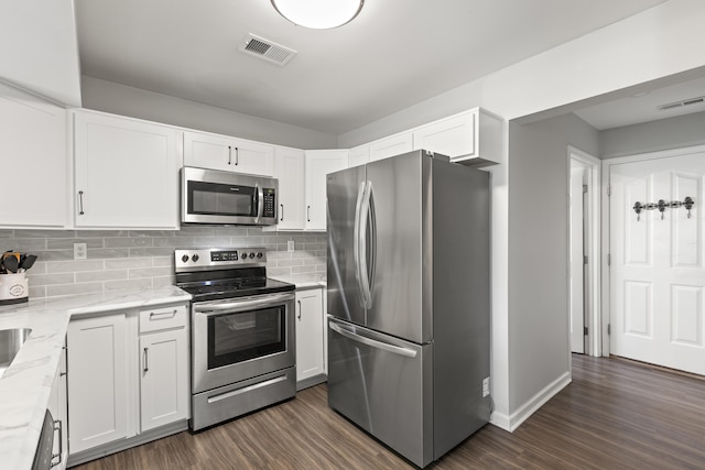 kitchen featuring stainless steel appliances, light stone countertops, dark wood-style flooring, and white cabinets