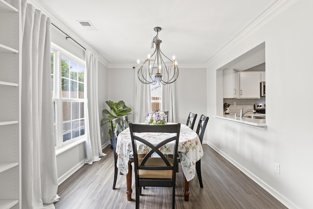 dining area featuring baseboards, a chandelier, dark wood-type flooring, and ornamental molding